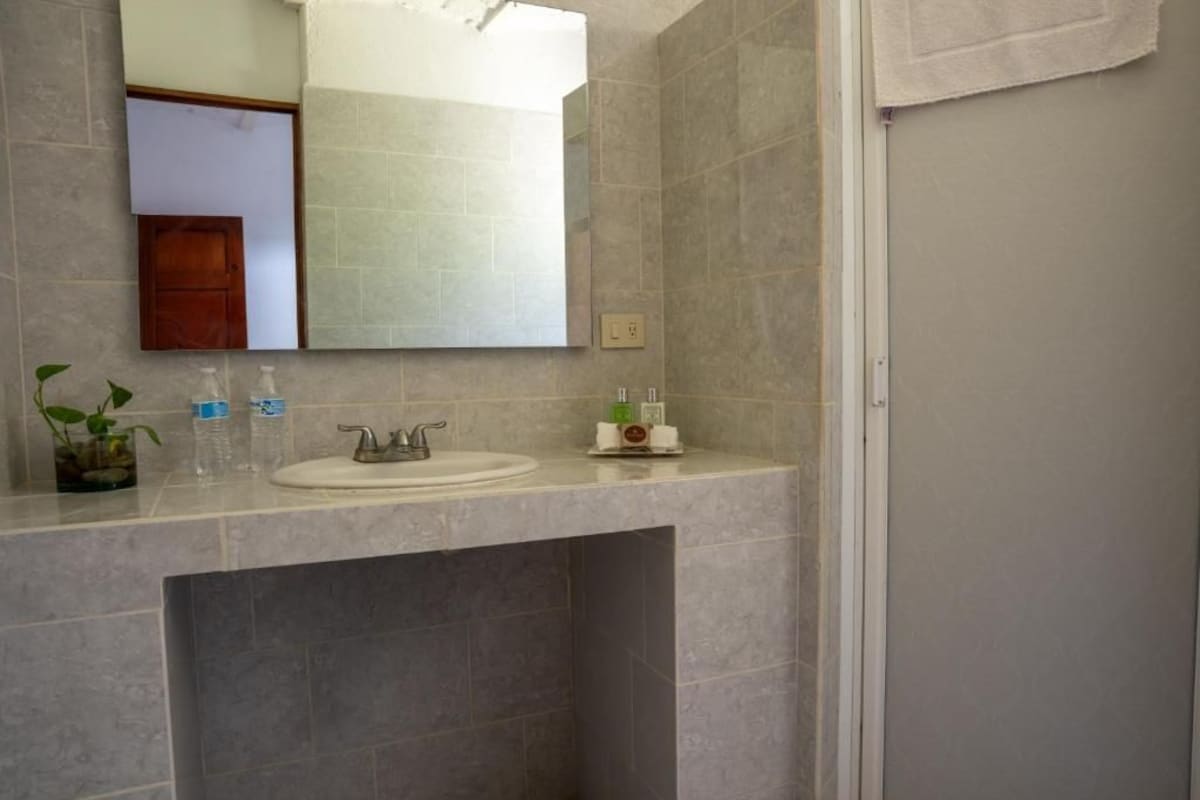 Een badkamer met een wastafel, spiegel en handdoekhouder.