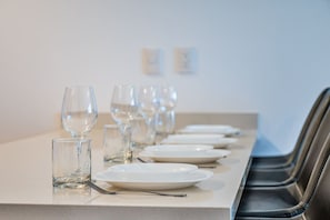 A dining table set with plates, glasses, and cutlery, with chairs aligned on one side. - 2 BR Penthouse | Private Pool & Parking | Sleeps 8 (Playa del Carmen)