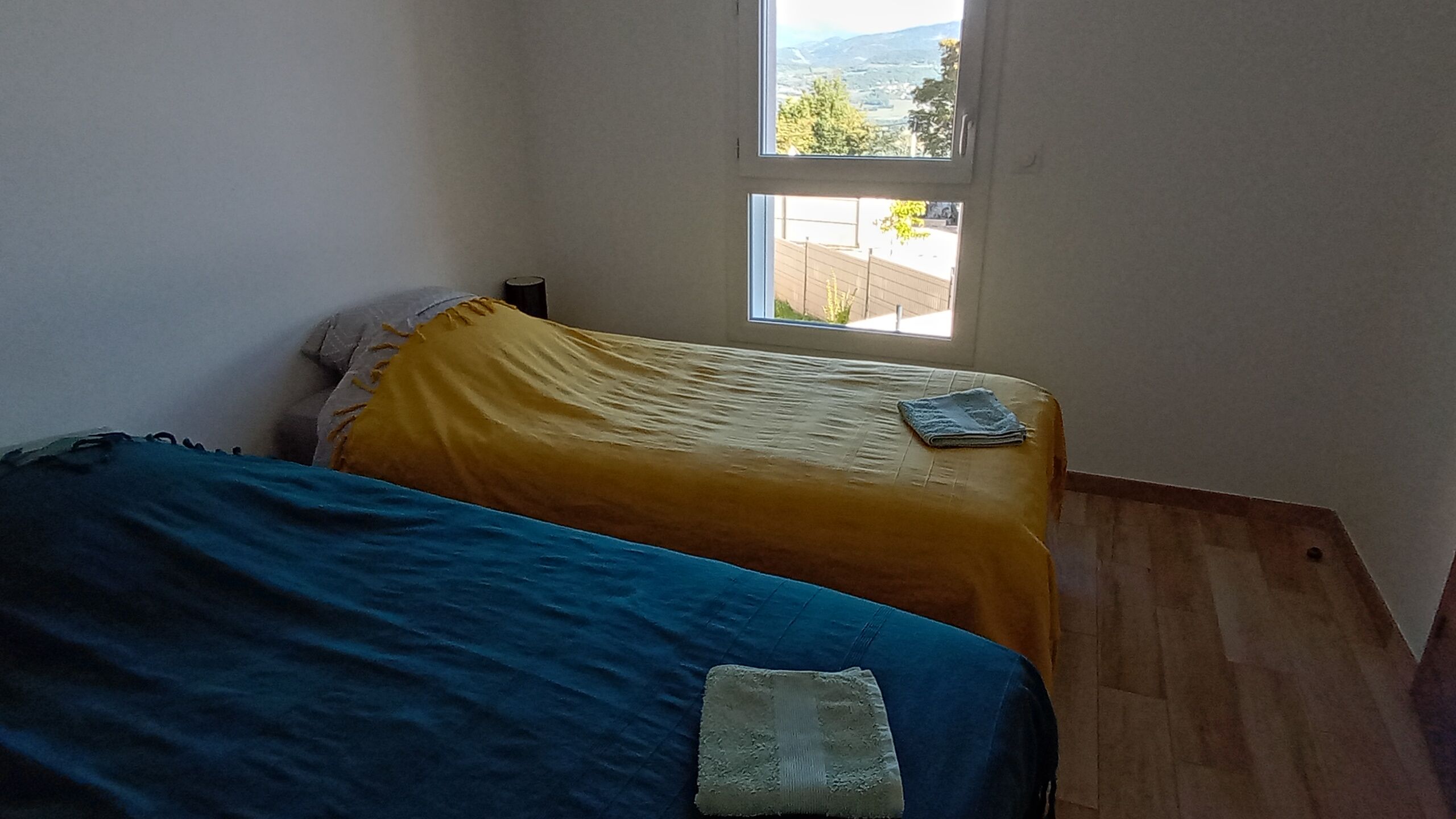 Une chambre avec deux lits, une fenêtre et une vue sur l’extérieur.