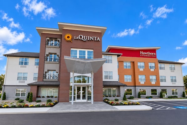 Et hotel med en central indgang, et solsymbol og et skilt for Hawthorn Extended Stay.