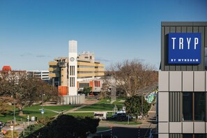 Un edificio moderno con un cartel llamativo que dice 'TRYP BY WYNDHAM'.