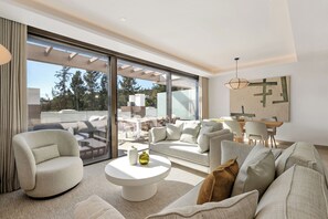 A modern living room with a large sliding glass door leading to an outdoor patio area.