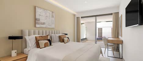 Una habitación de hotel con cama, mesitas de noche, escritorio y televisor.