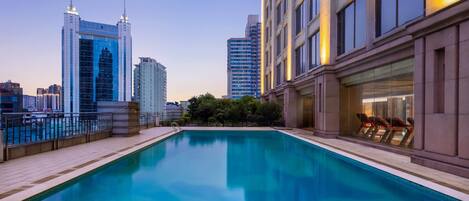 A rooftop pool with a city skyline in the background.