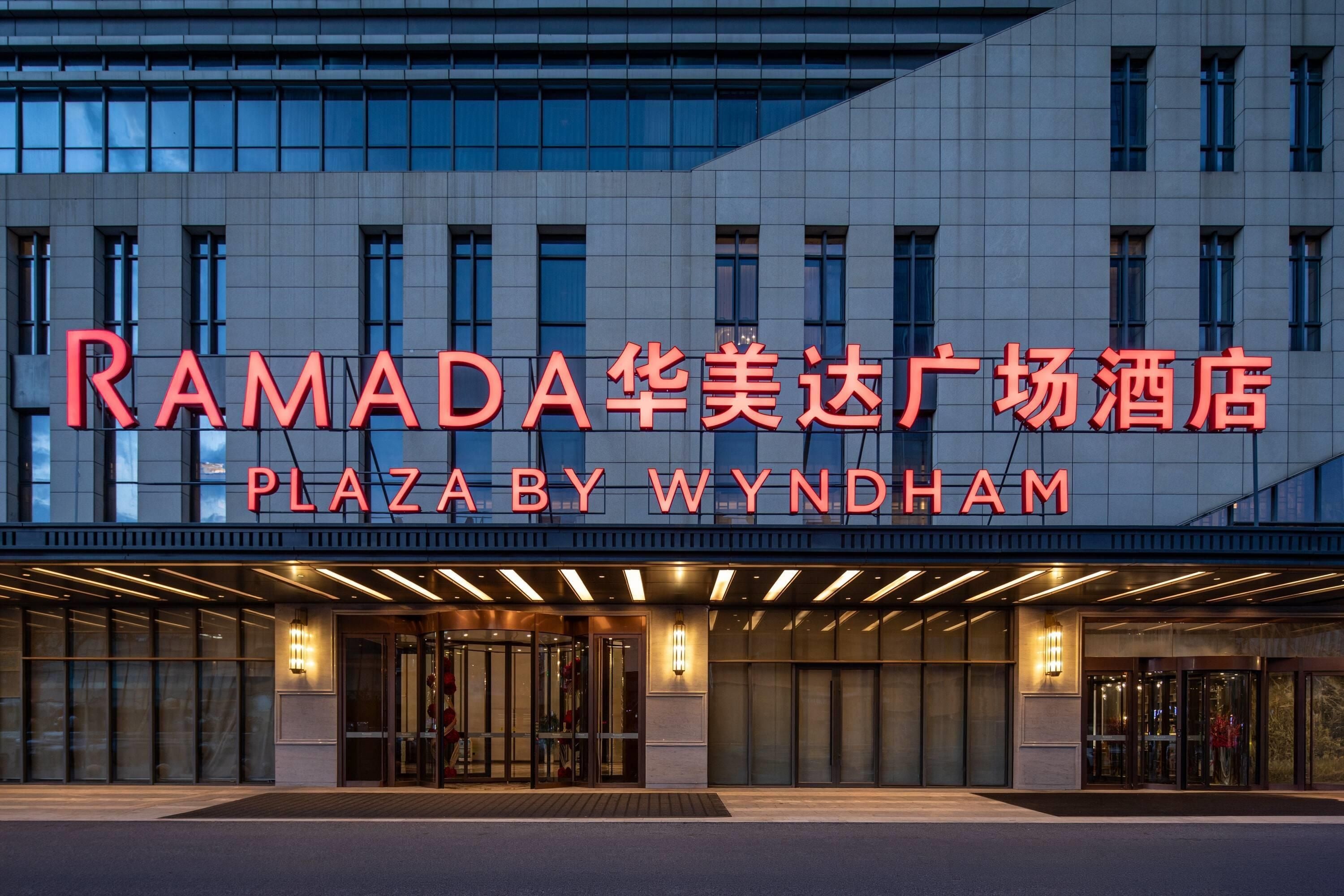 A hotel entrance with a modern facade and illuminated signage.