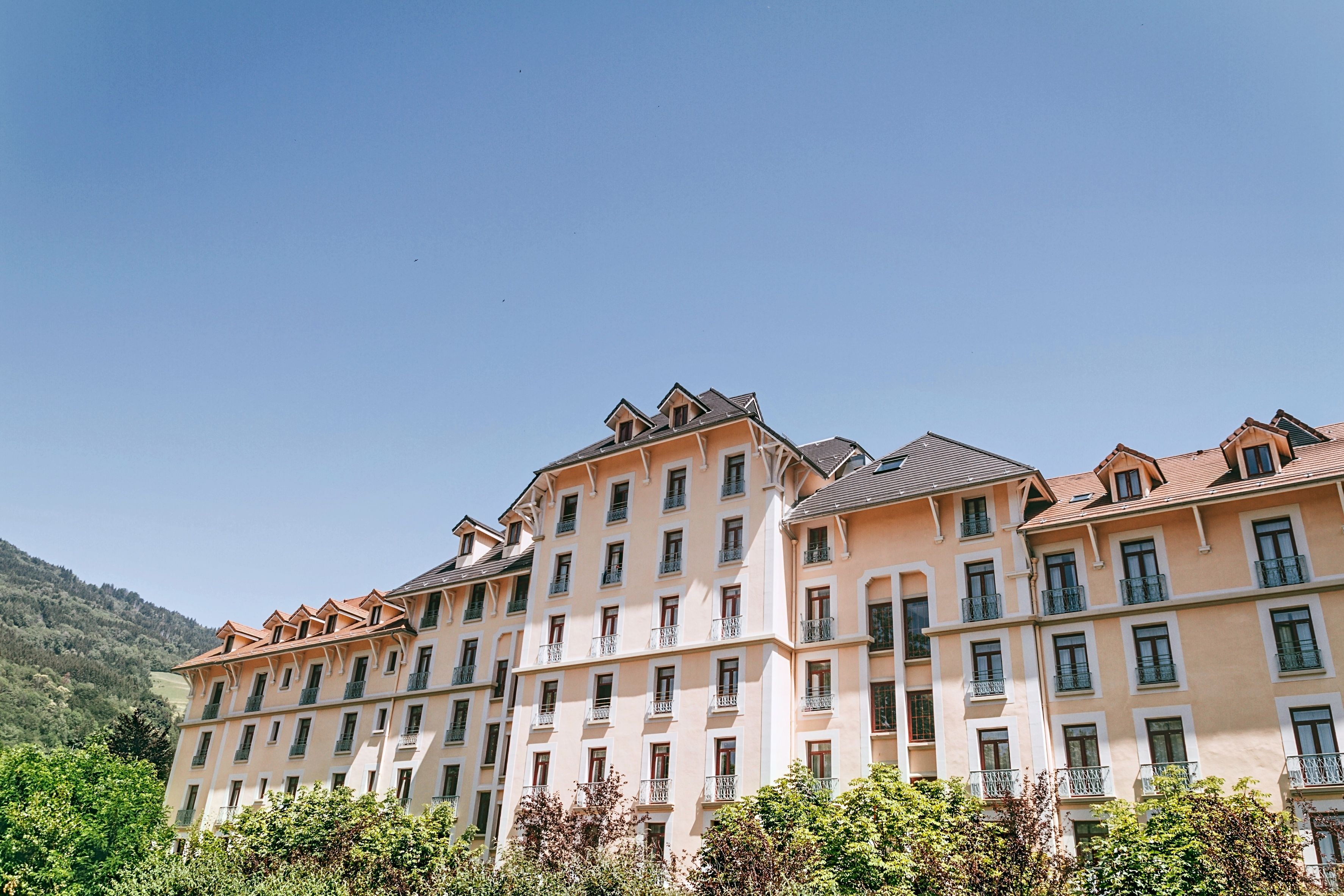 Un hotel de varios pisos con un estilo arquitectónico uniforme, con balcones y una fachada consistente.