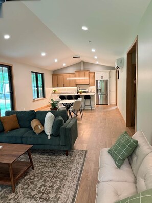 Un apartamento moderno con sala de estar, comedor y cocina.