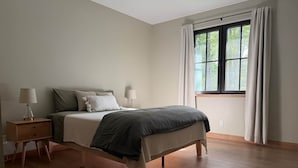 Una camera da letto con un letto, comodini e una finestra con tende.