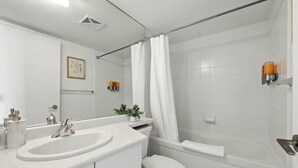 Uma casa de banho moderna com banheira, sanita e lavatório.