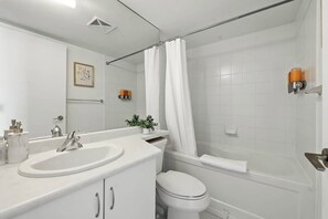 Ein modernes Badezimmer mit Badewanne, Toilette und Waschbecken.