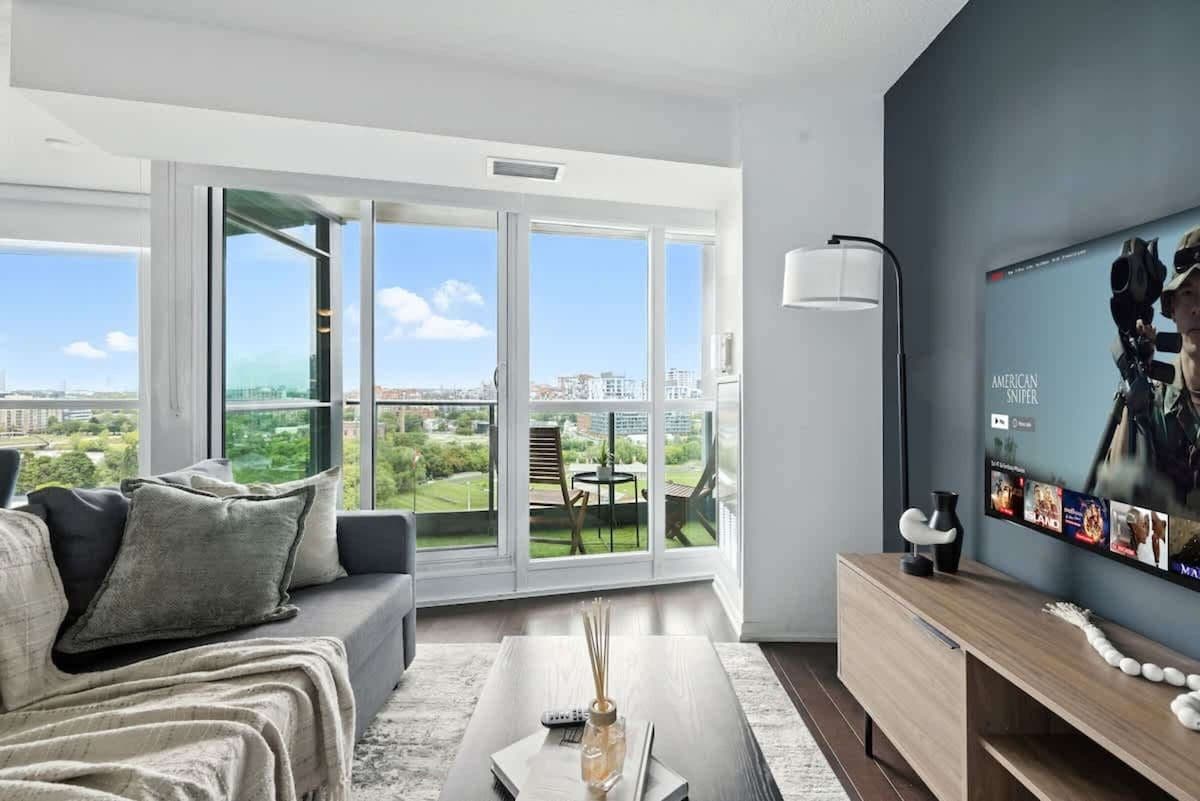 Ein modernes Wohnzimmer mit einer Couch, einem Couchtisch und einem Fernseher an der Wand.