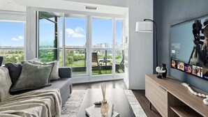 Uma sala de estar moderna com um sofá, mesa de centro e uma TV na parede.