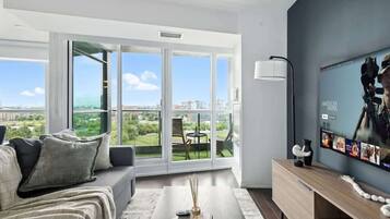 Una sala de estar moderna con un sofá, una mesa de centro y un televisor en la pared.