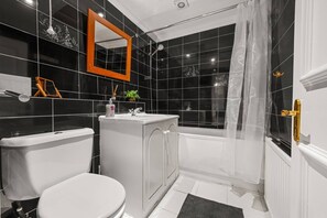 A bathroom with a toilet, sink, and shower area. - City Centre 3 bed flat with lift and roof terrace (Greater London)