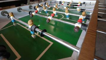Ett bordfotbollsspel med flera spelare och en grön spelyta.