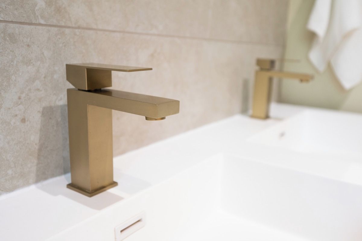 A bathroom with a modern faucet and a mirror.