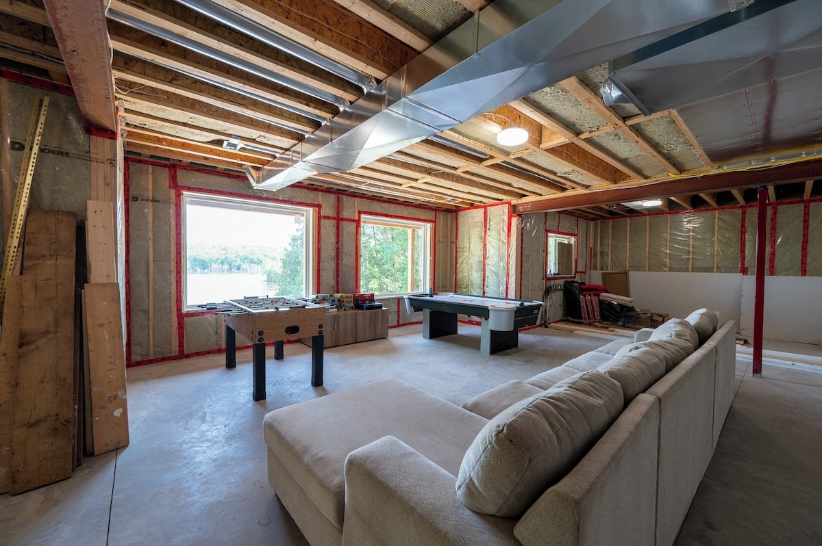 Una habitación con vigas de madera a la vista, mesa de billar y sofá.