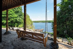 Puinen riipputuoli katetulla alueella, josta avautuu näkymä järvelle ja metsään.