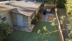 En bostadsfastighet med en inhägnad trädgård, en täckt uteplats och ett garage.