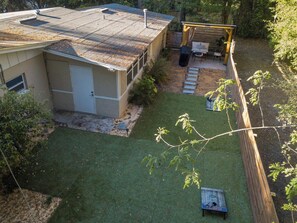 Een woonhuis met een omheinde tuin, een overdekt terras en een garage.