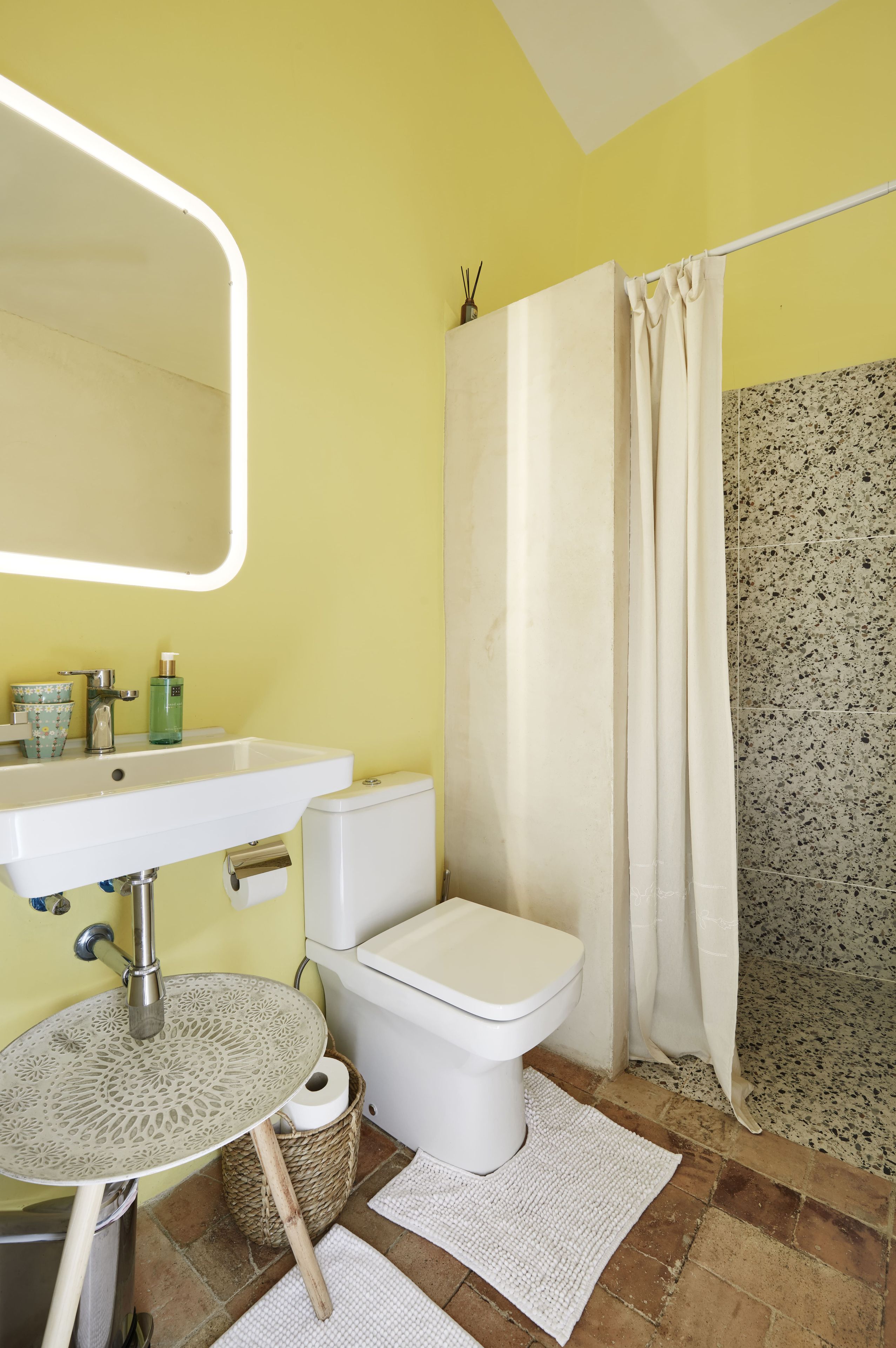 Un baño con lavamanos blanco, inodoro y cortina de ducha.