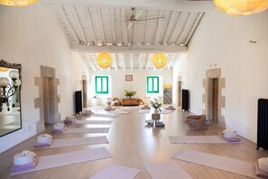 A yoga studio with mats, a ceiling fan, and a wooden floor.