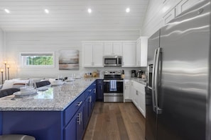 A modern kitchen with white cabinets, stainless steel appliances, and a granite countertop. - Under the Stars: Secluded, Hot Tub, Firepit, Pets (Broken Bow)