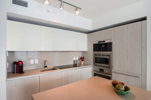 Eine moderne Küche mit einer zentralen Kochinsel, integrierten Geräten und einem minimalistischen Design.