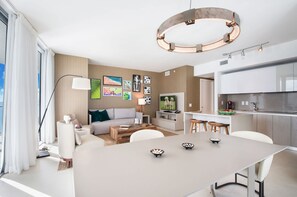 Una sala de estar moderna con un sofá, una mesa de centro y una obra de arte en la pared.