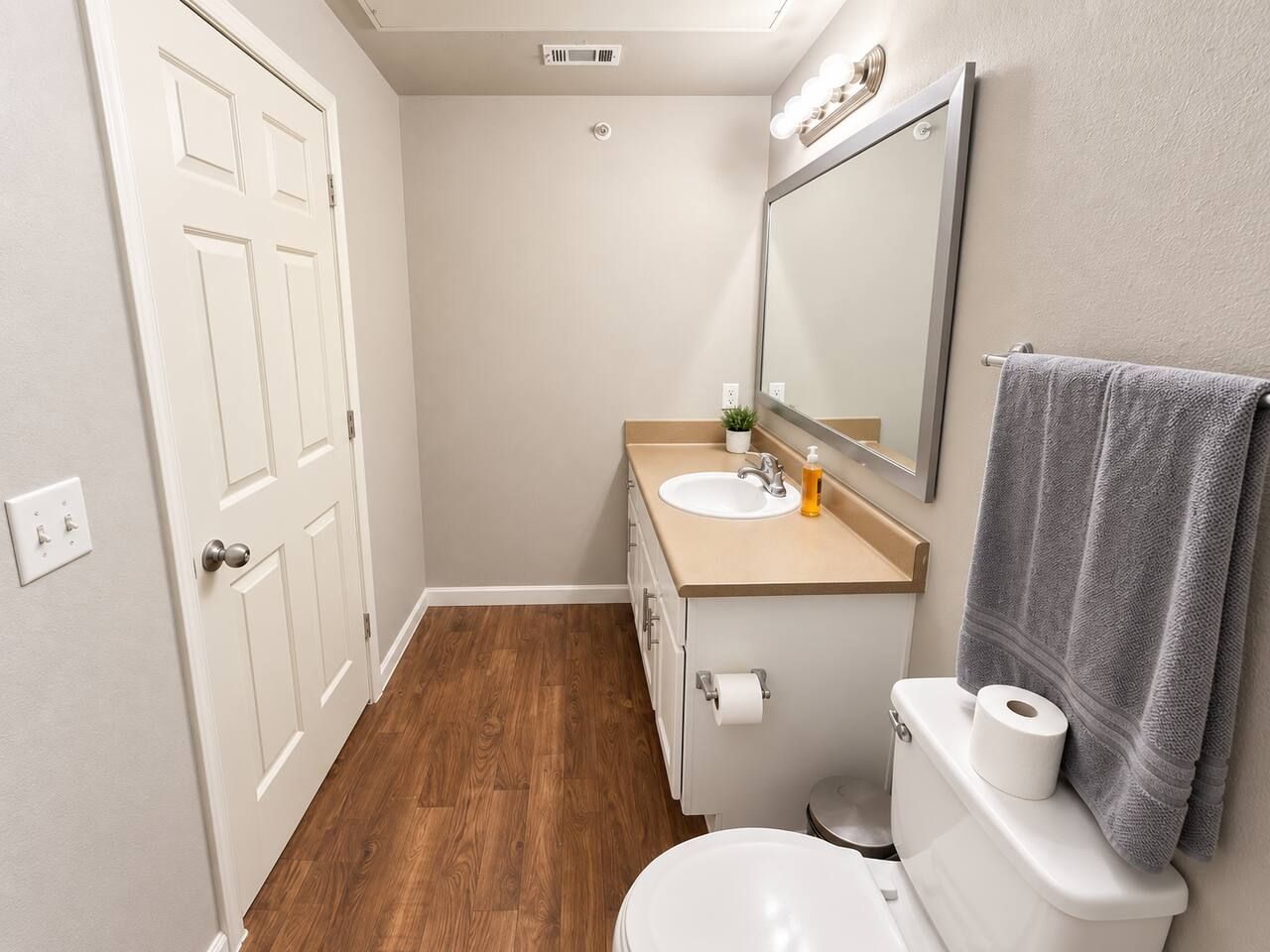 Ein kleines Badezimmer mit Toilette, Waschbecken und Spiegel.