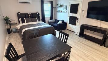 A modern bedroom with a bed, bedside table, and a ceiling fan.