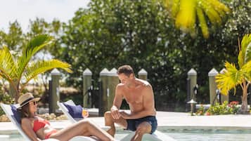 A poolside area with lounge chairs and umbrellas.