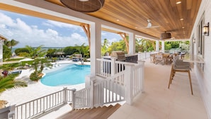 A covered outdoor area with a pool, wooden deck, and seating. - Albury Landing in Tavernier (Tavernier)