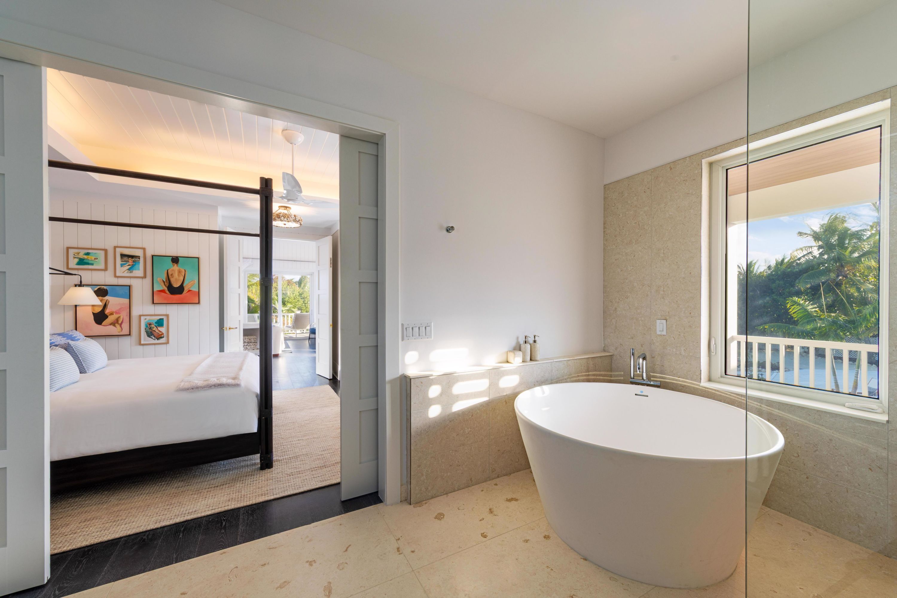 A modern bathroom with a freestanding bathtub, a large mirror, and a view of the outdoors.