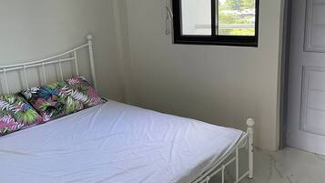 Ein Schlafzimmer mit Bett, Fenster und Tür.
