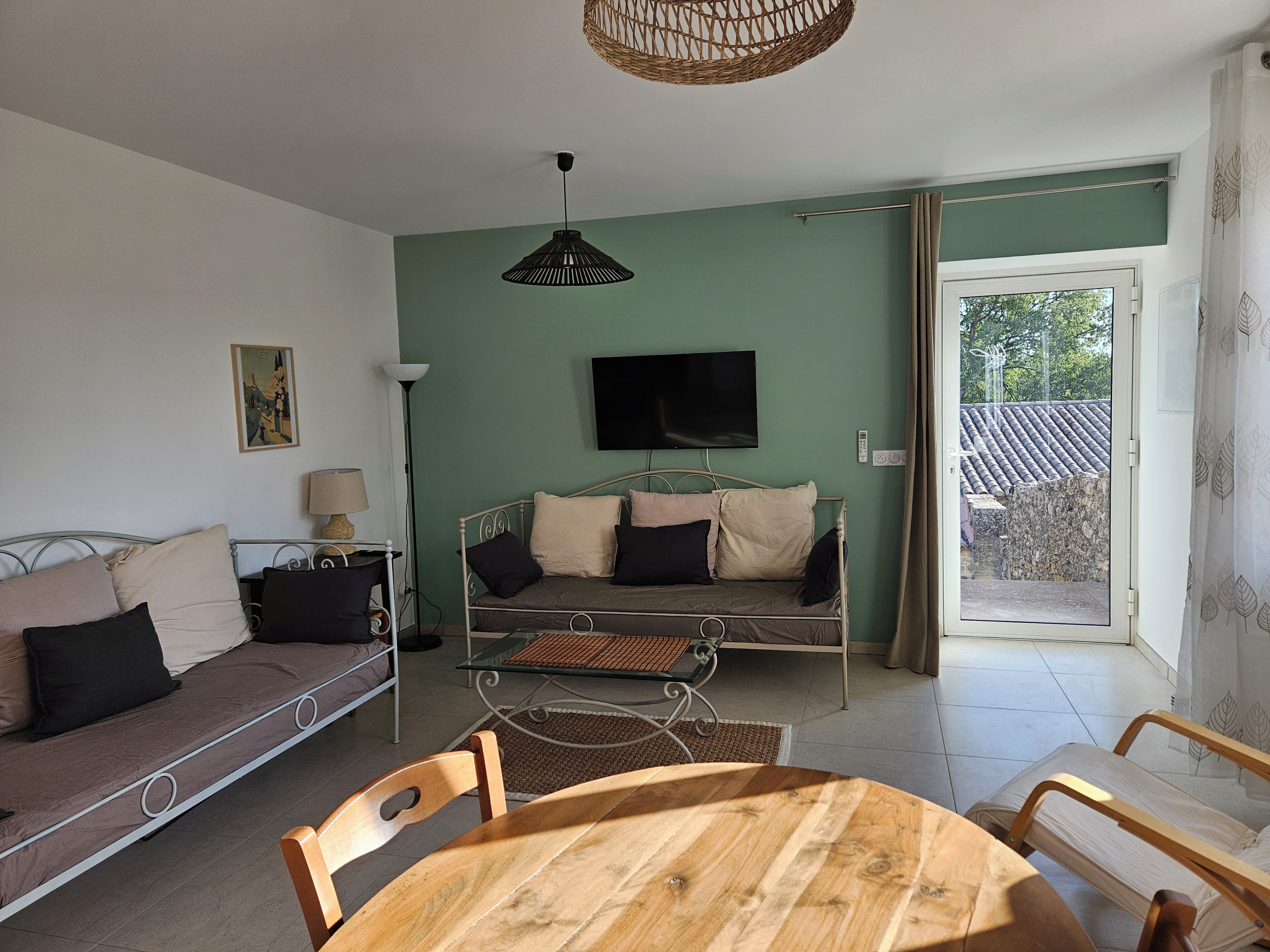 Una habitación con cama, sofá, mesa de comedor y televisión.
