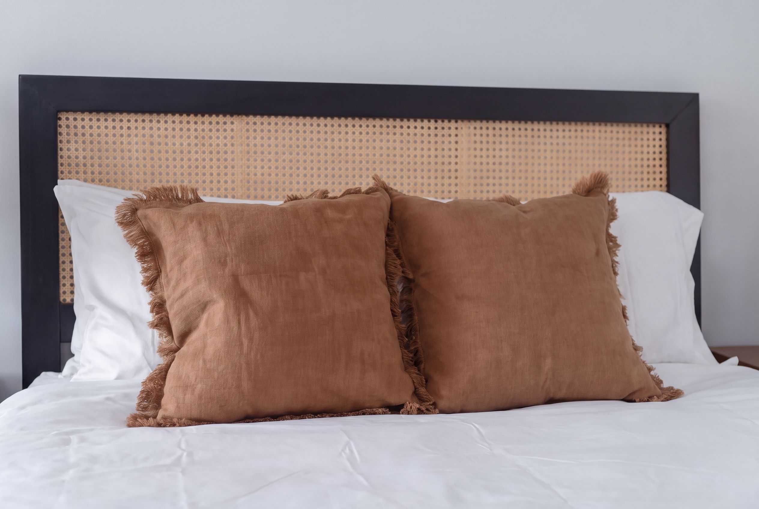 Una cama con dos almohadas y cabecera.