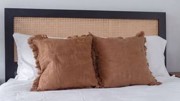 Una cama con dos almohadas y cabecera.