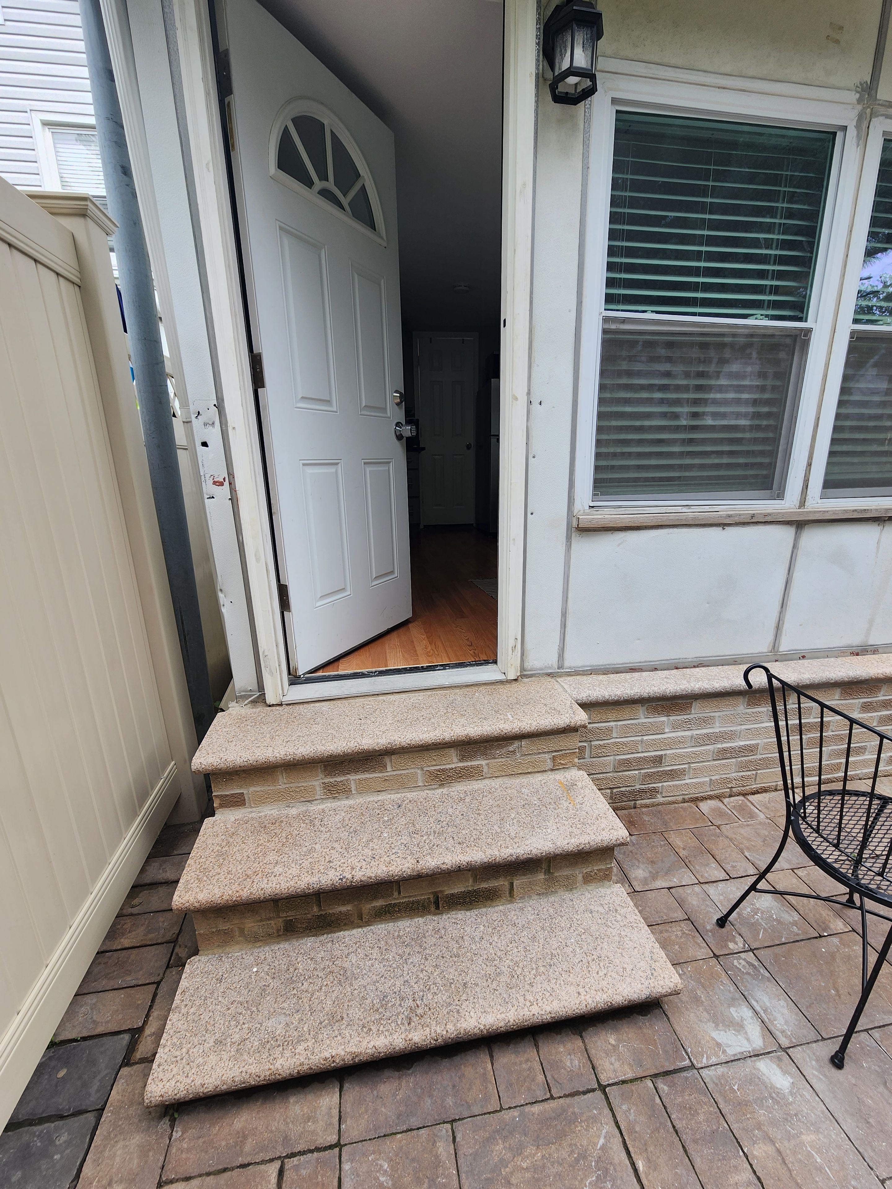A front door with a set of stone steps leading to a porch.