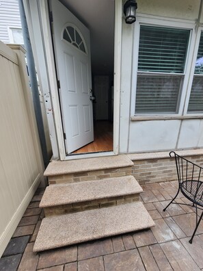 A front door with a set of stone steps leading to a porch. - Cozy studio in a lovely Forest Hills neighborhood (Forest Hills)