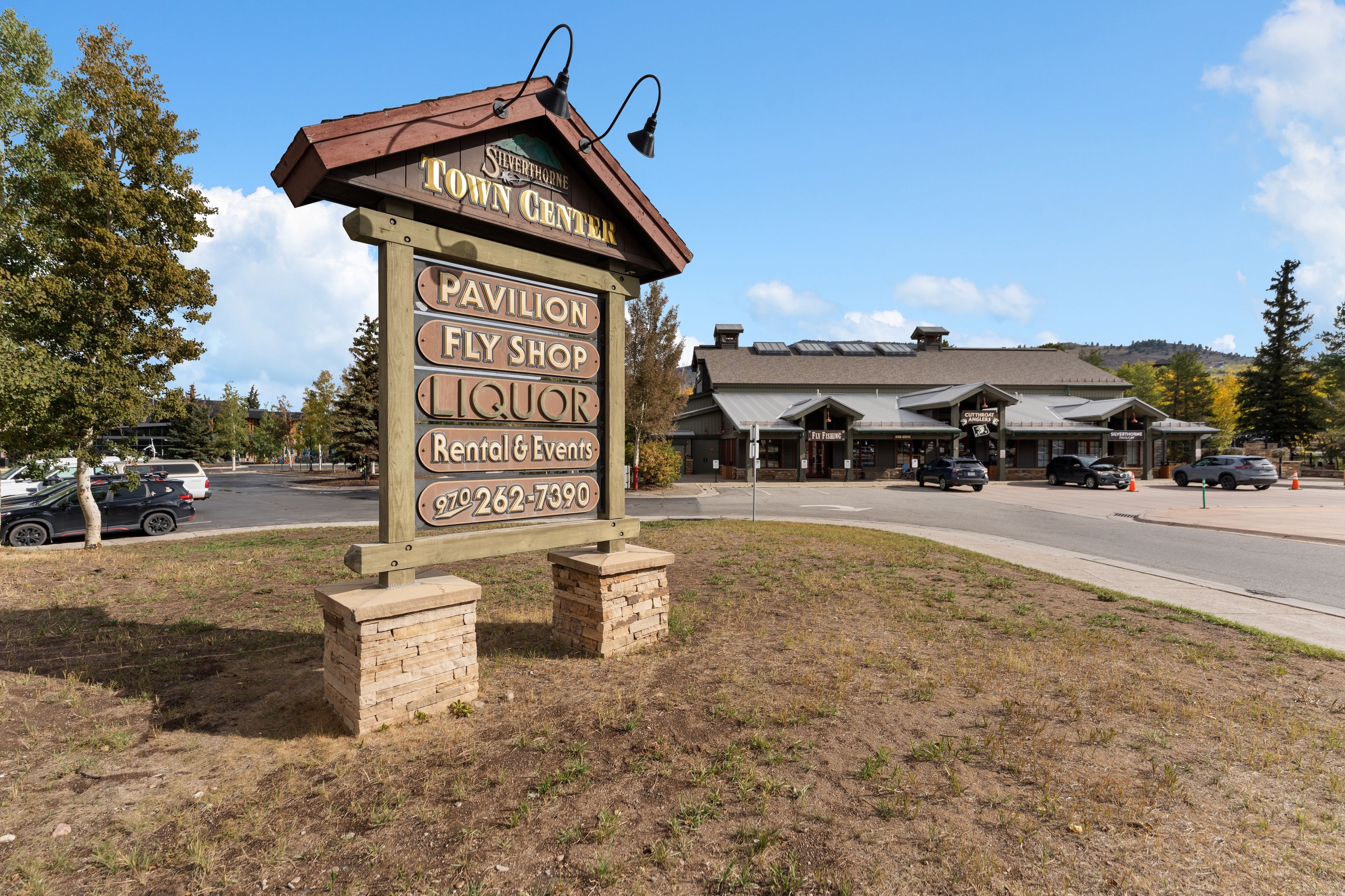 A wooden signboard with business names and a phone number for Silverthorne Inn.