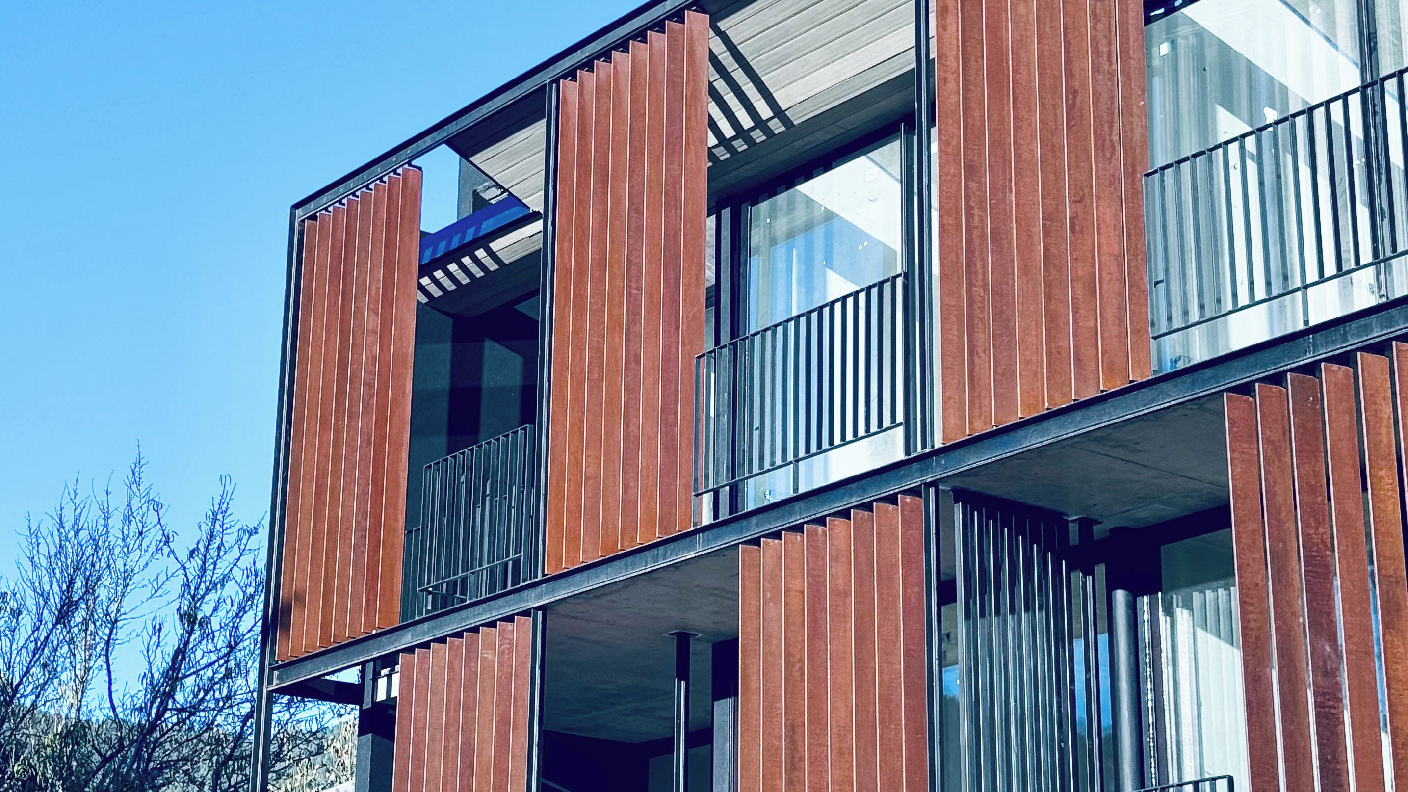 A modern building with large windows and balconies.