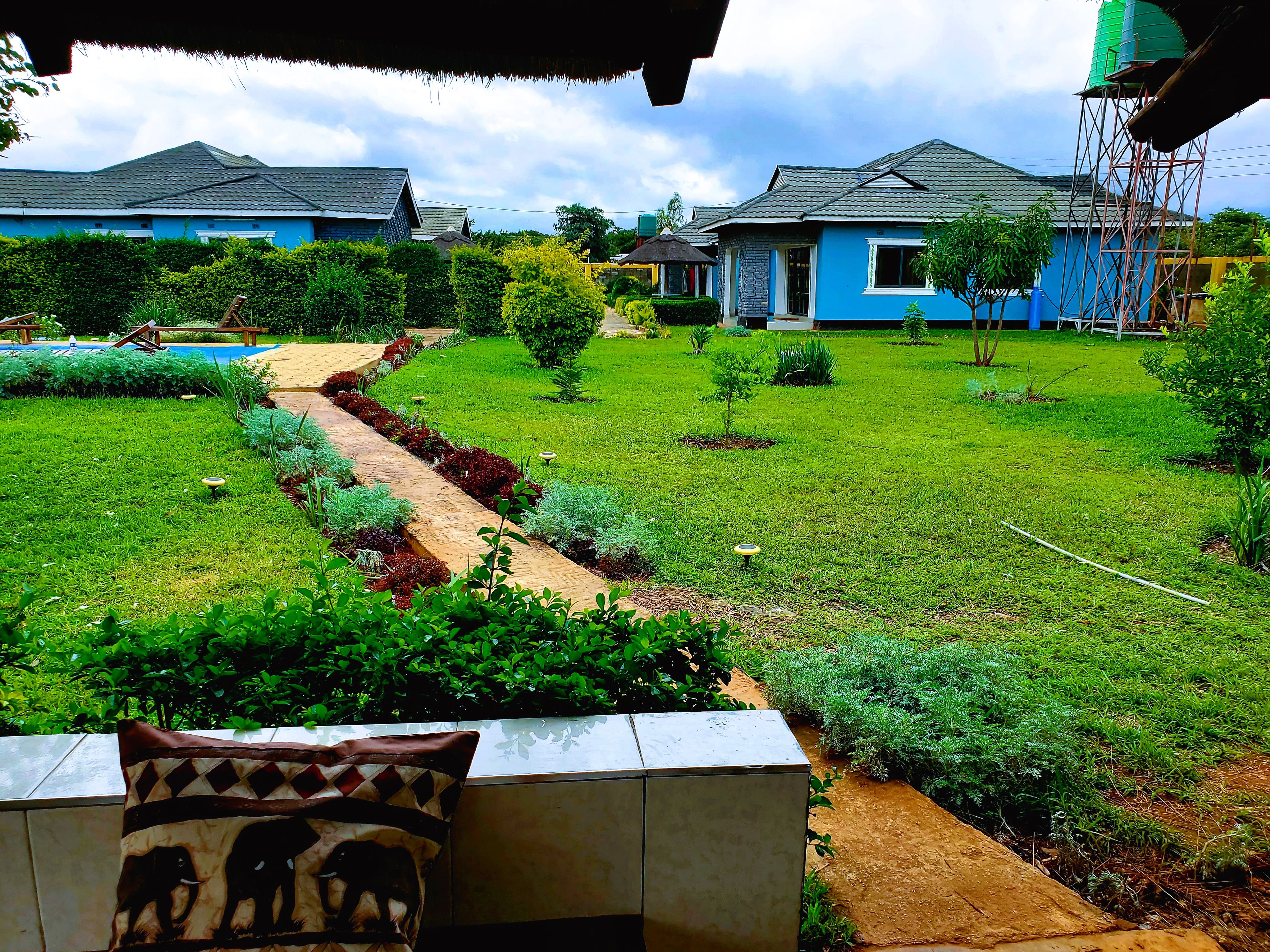 A residential area with houses, a well-maintained lawn, and a pathway.