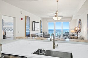 A modern kitchen with a large island, a built-in dishwasher, and a view of the ocean. - Steps to The Beach • Resort Pools • Pier Park (Panama City Beach)