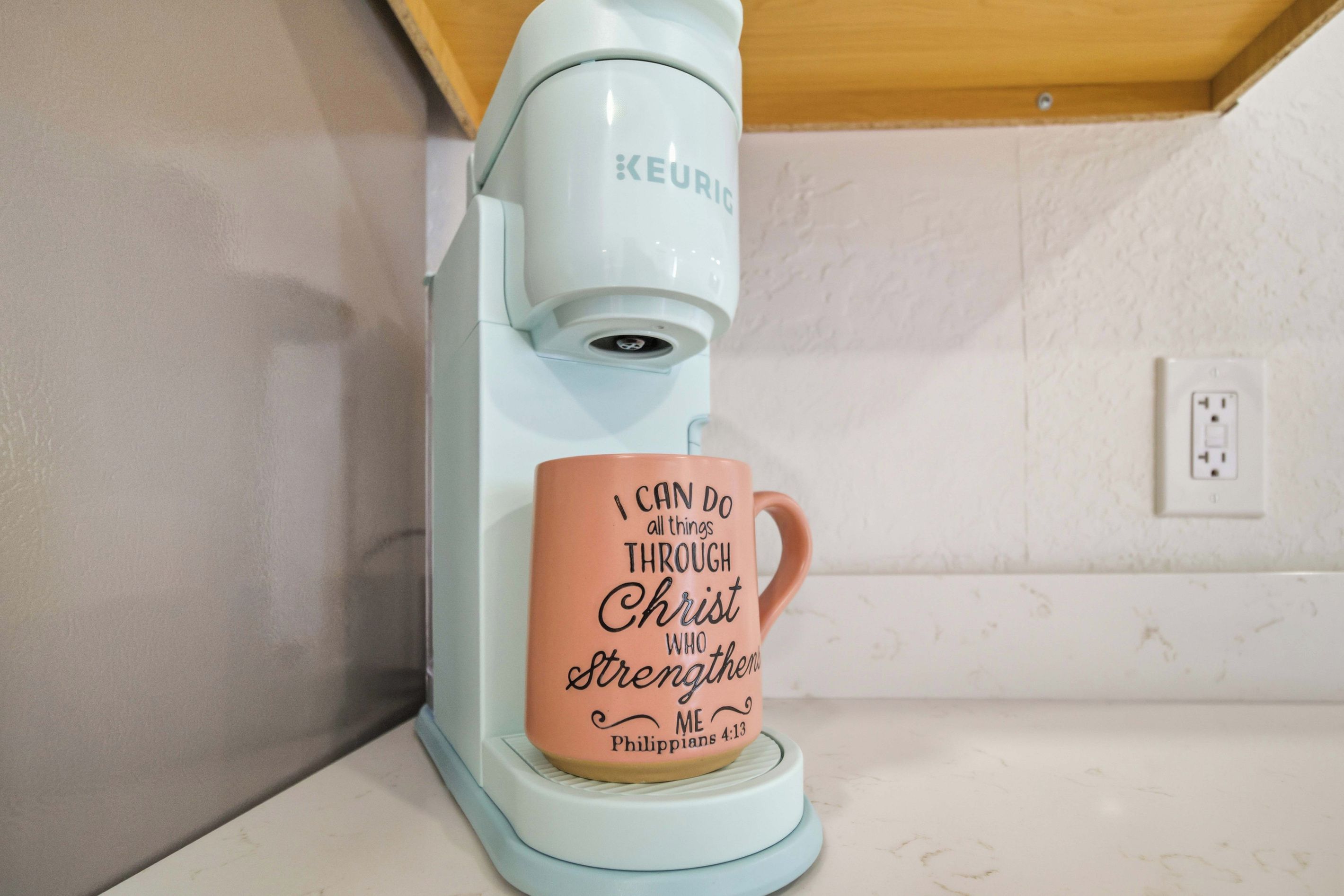 A Keurig coffee maker with a mug on its drip tray.