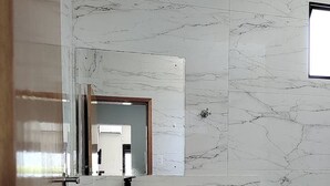 Ein modernes Badezimmer mit Marmorwaschtisch, Toilette und Badewanne.