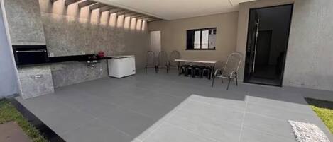 A modern kitchen with a built-in oven, a dining area with a table and chairs, and a large window.
