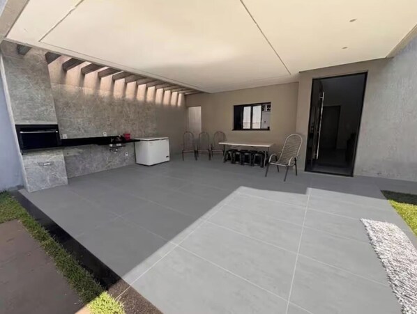 A modern kitchen with a built-in oven, a dining area with a table and chairs, and a large window.