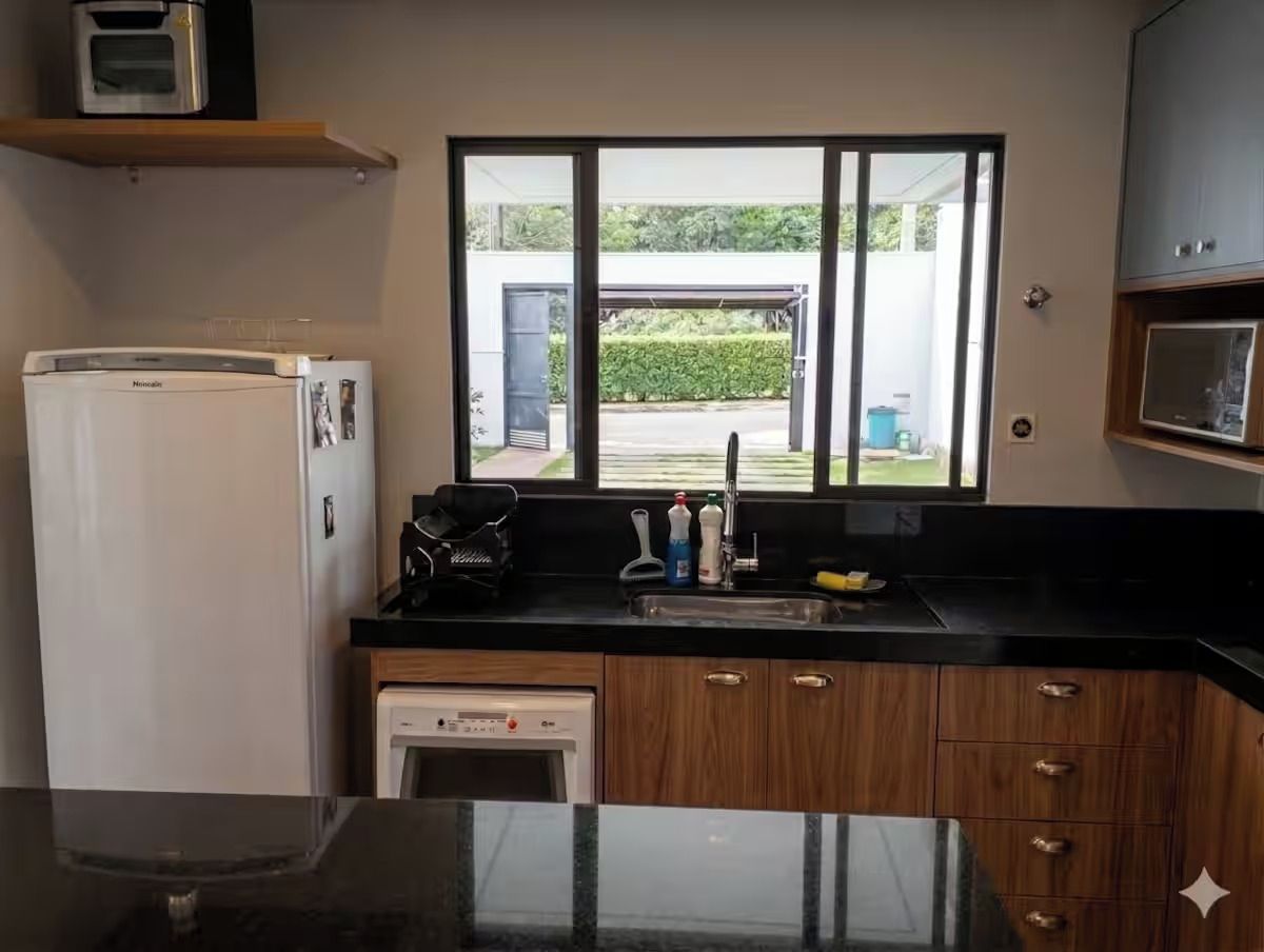 A compact kitchen with a refrigerator, dishwasher, and a window providing a view of the outdoors.