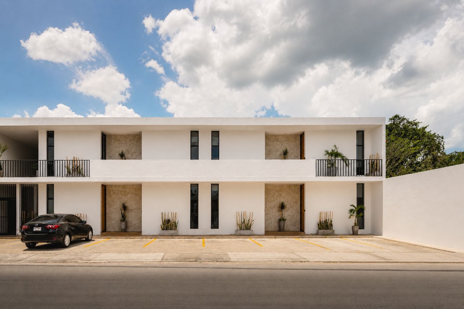 Un edificio moderno de varios pisos con un área de estacionamiento al frente.